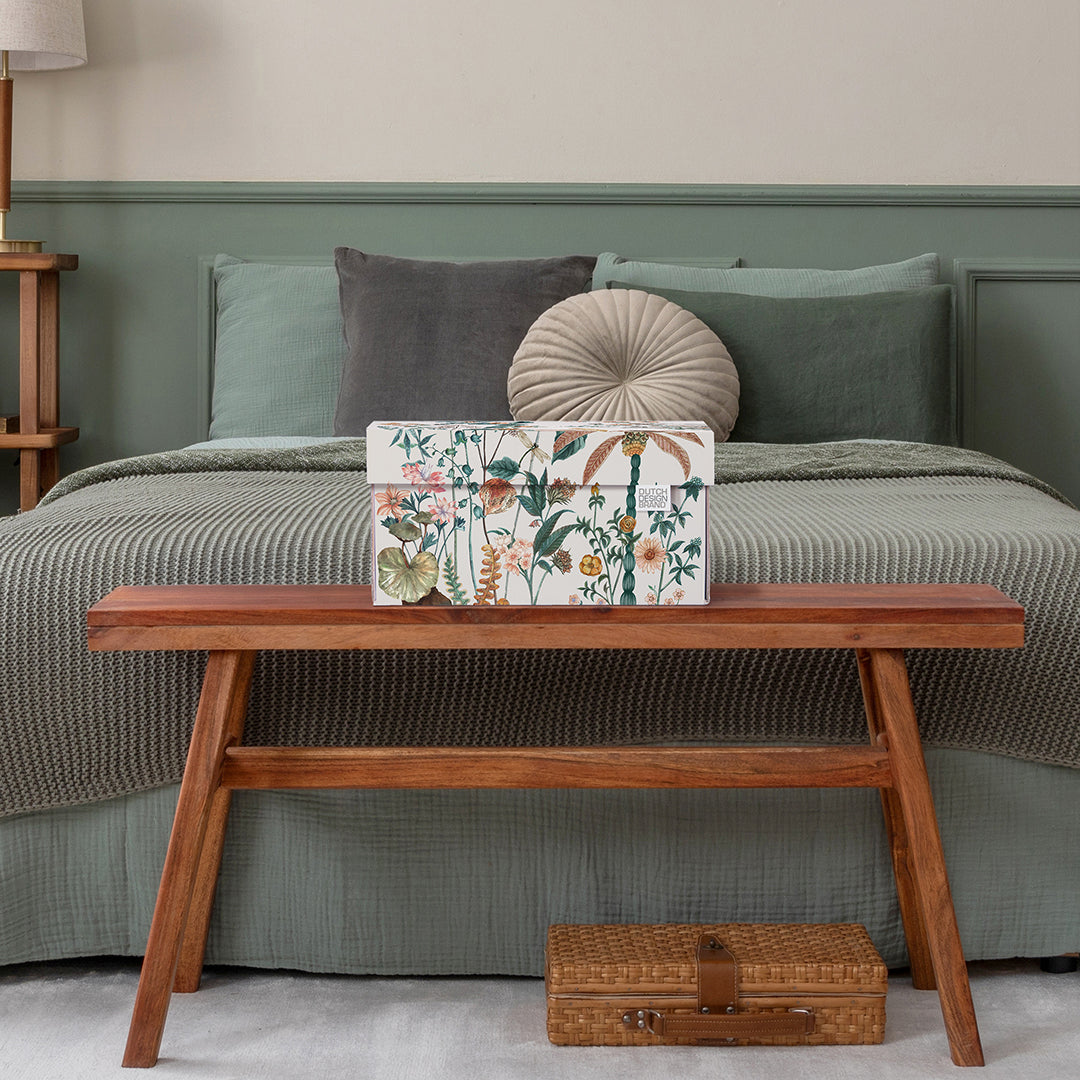 Stijlvolle opbergdoos met tropisch bloemen-, palm- en libellenmotief in een slaapkamer.