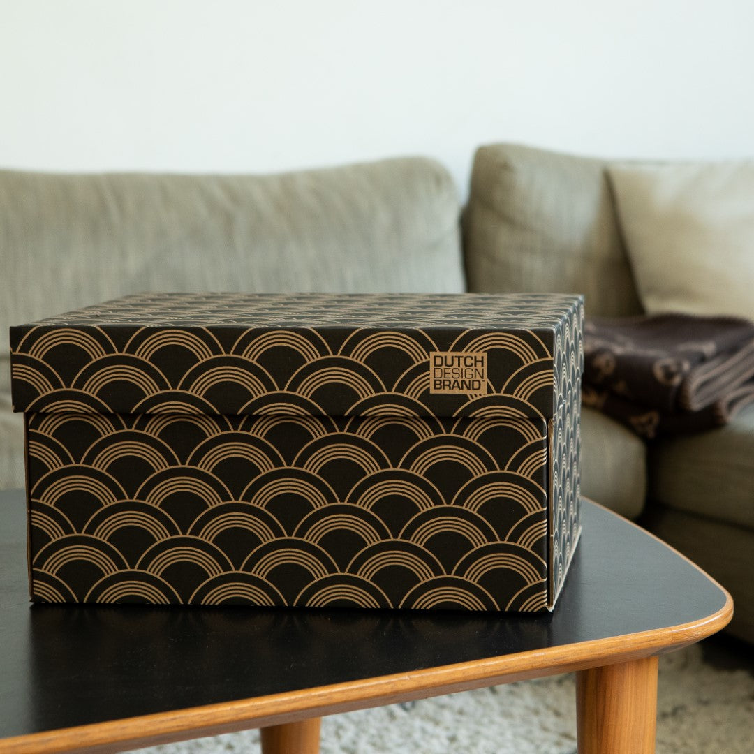 Opbergbox met zwart met witte print met boogjes op een tafel.